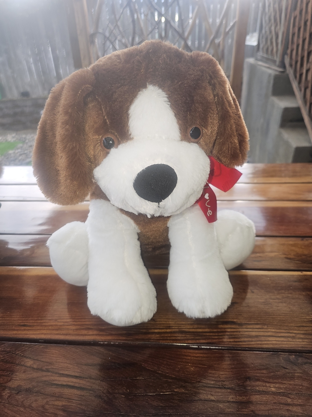 brown and white dog plush stuffed animal featuring a red ribbon printed with the